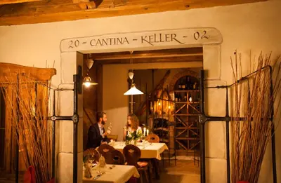 a man sitting at a table in a wine cellar at Hotel Comfort Erica Dolomiti Val d'Adige in Salorno sulla Strada del Vino