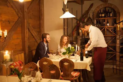 a group of people sitting around a table in a restaurant at Hotel Comfort Erica Dolomiti Val d'Adige in Salorno sulla Strada del Vino
