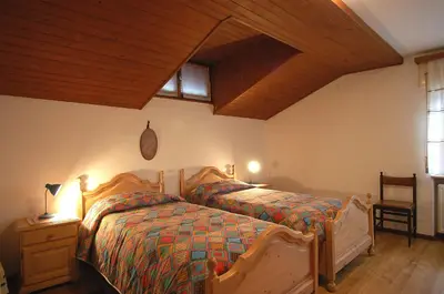 a bedroom with a bed and a wooden ceiling at Casa De Biasio PM in Falcade