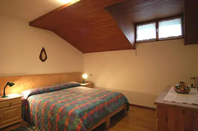a bedroom with a bed and a wooden ceiling at Casa De Biasio PM in Falcade