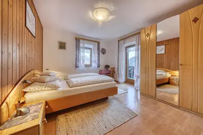 a bedroom with a large bed and a mirror at Goldbichlhof in Lana