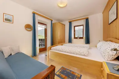a bedroom with two beds and a window at Goldbichlhof in Lana