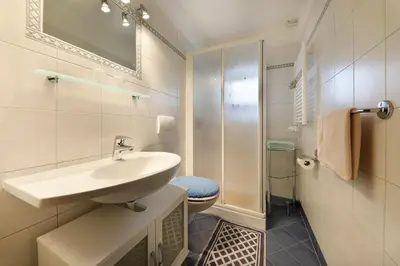 a white bathroom with a sink and a toilet at Goldbichlhof in Lana