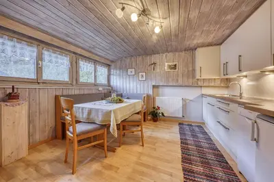 a kitchen with a table and chairs in a room at Goldbichlhof in Lana
