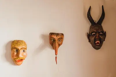 three masks hanging on a wall at Hotel Arnika in Pozza di Fassa