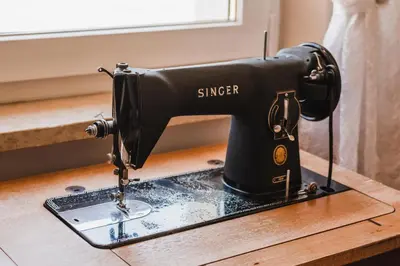 a black singer sewing machine sitting on a table at Hotel Arnika in Pozza di Fassa