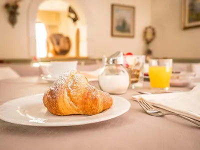 a pastry sitting on a plate on a table at Hotel Arnika in Pozza di Fassa