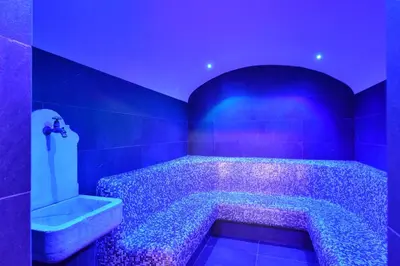a blue bathroom with a tub with a sink at Park Hotel Bellacosta in Cavalese