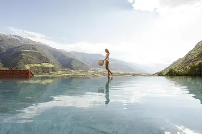 a woman standing in a body of water at Preidlhof Luxury Dolce Vita Resort in Naturno