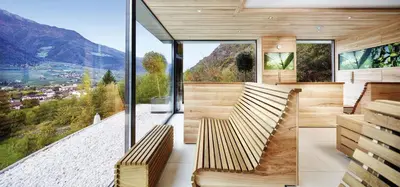 a room with two benches and a large window at Preidlhof Luxury Dolce Vita Resort in Naturno