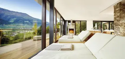 a living room with a couch and a fireplace at Preidlhof Luxury Dolce Vita Resort in Naturno