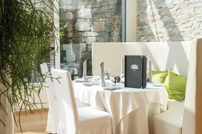 a white table with white chairs and a book on it at Preidlhof Luxury Dolce Vita Resort in Naturno