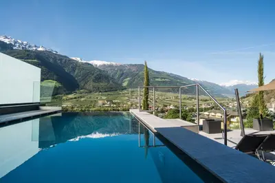 a swimming pool with a view of the mountains at Preidlhof Luxury Dolce Vita Resort in Naturno