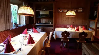 a dining room with two tables with red napkins at Hotel Villa Emilia in Ortisei