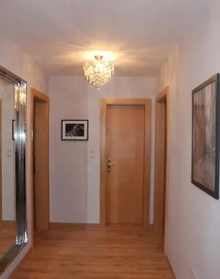 a hallway with a door and a chandelier at Villa Falkner in Tirolo