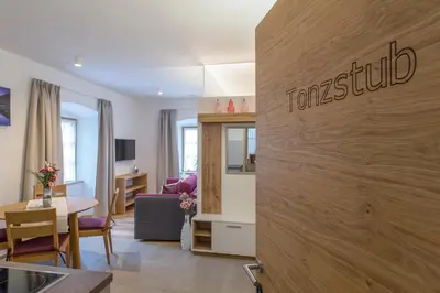 a living room with a tennyson sign on a wall at Ansitz Mairhof in Parcines