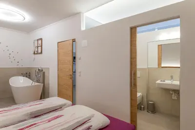 a bathroom with a bed and a sink and a mirror at Ansitz Mairhof in Parcines