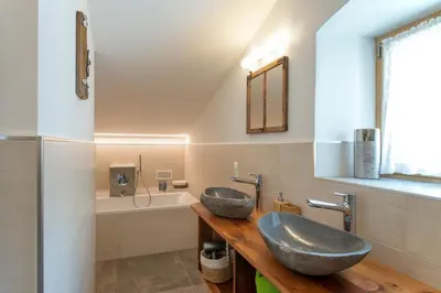 a bathroom with two sinks and a tub at Ansitz Mairhof in Parcines