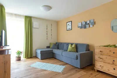 a living room with a blue couch in front of a window at Ansitz Mairhof in Parcines
