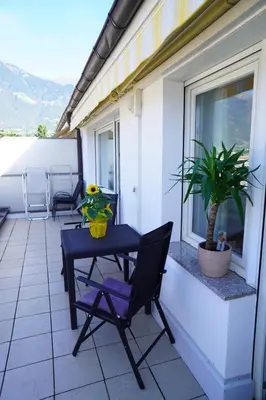 a patio with a table and chairs on a balcony at Apartment Roma in Merano