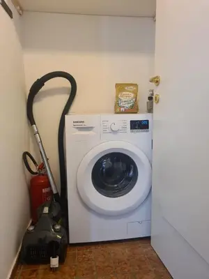 a washing machine in a room with a vacuum at Apartment Roma in Merano