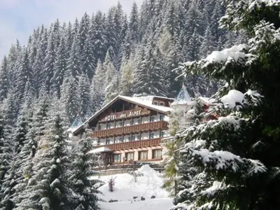 a large building on a snow covered mountain at Hotel Des Alpes in Soraga