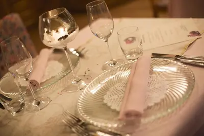 a table with wine glasses and plates on it at Hotel Des Alpes in Soraga