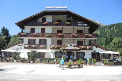 a man standing in front of a large building at Hotel Torretta in Bellamonte