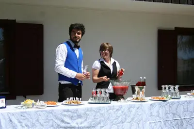 a man and a woman standing next to a table with food at Hotel Torretta in Bellamonte