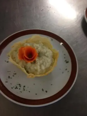 a plate of mashed potatoes with a tomato on it at Hotel Torretta in Bellamonte
