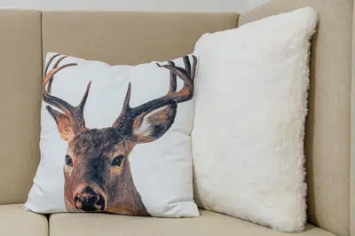 a cushion with a deer head on a couch at Hotel Torretta in Bellamonte