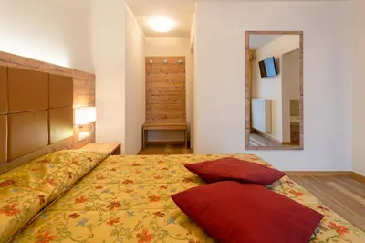 a bedroom with a bed with two pillows and a mirror at Hotel Torretta in Bellamonte