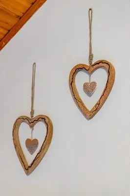 two wooden hearts hanging on a wall at Hotel Torretta in Bellamonte