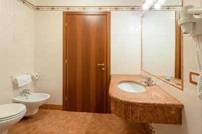 a bathroom with a sink and a toilet at Hotel Torretta in Bellamonte