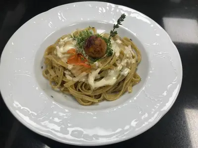 a plate of spaghetti with a meatball on it at Hotel Olaga in Valdaora