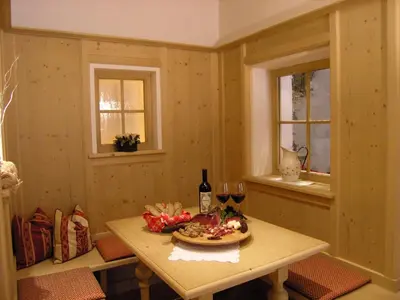 a room with a table with a plate of food and two windows at Hotel Olaga in Valdaora