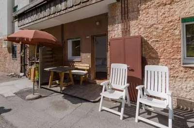 two chairs and a table and an umbrella on a patio at Appartamento Continental - 8 posti letto in San Vito di Cadore