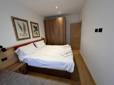 a small bedroom with a bed with white sheets at Appartamento Continental - 8 posti letto in San Vito di Cadore