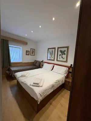 a bedroom with a large bed and a couch at Appartamento Continental - 8 posti letto in San Vito di Cadore