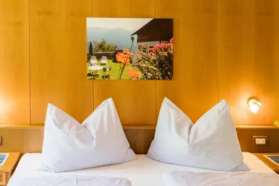 a bed with white pillows and a picture on the wall at Thalerhof Tiers in Tires