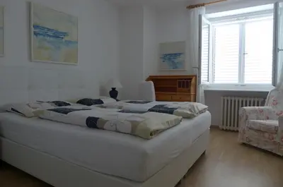 a bedroom with two beds and a chair at Appartement Trafoier in Tirolo