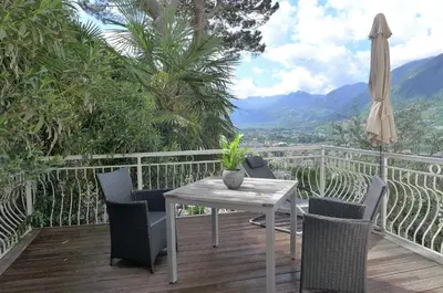 a table and chairs on a deck with an umbrella at Appartement Trafoier in Tirolo