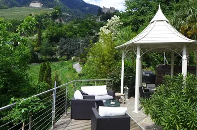 a gazebo with chairs and a table on a deck at Appartement Trafoier in Tirolo