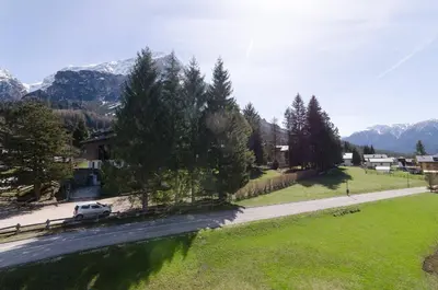 a car parked on a road with mountains in the background at Continental 101- 4 beds in San Vito di Cadore