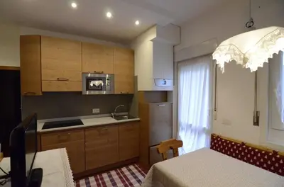a kitchen with a sink and a microwave and a table at Continental 101- 4 beds in San Vito di Cadore