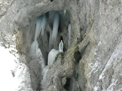 a man standing on a ice cave in a glacier at Hotel Garnì Ai Serrai in Rocca Pietore
