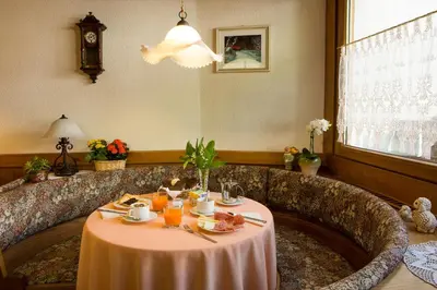a dining room with a table with food on it at Hotel Garnì Ai Serrai in Rocca Pietore
