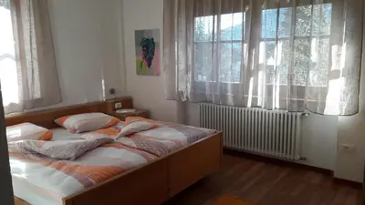 a bed in a bedroom with two windows at 