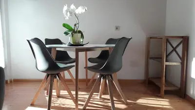 a dining room table with chairs and a vase on it at 