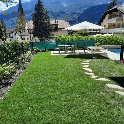 a lawn with a table and an umbrella next to a pool at 